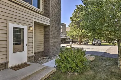 a house with a white door next to a street at 2 Mi to Rocky Mtn Natl Park Grand Lake Condo in Grand Lake