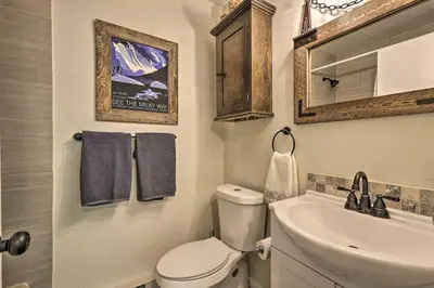 a bathroom with a toilet and a sink and a mirror at 2 Mi to Rocky Mtn Natl Park Grand Lake Condo in Grand Lake