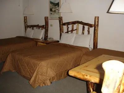 a hotel room with two beds and a table at Georgetown Mountain Inn in Georgetown