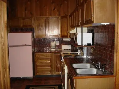 a kitchen with wooden cabinets and a white refrigerator at Georgetown Mountain Inn in Georgetown
