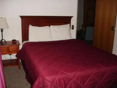 a bedroom with a bed with a red comforter at Georgetown Mountain Inn in Georgetown