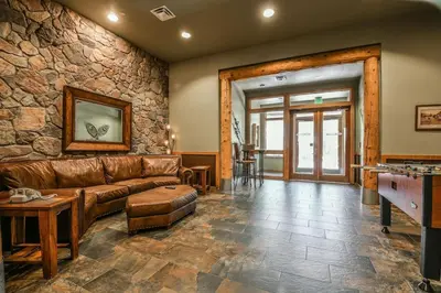 a living room with a couch and a stone wall at 8115 Arapahoe Lodge condo in Keystone