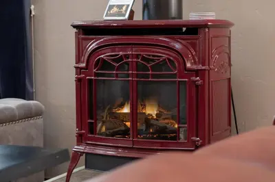 a red woodburning stove in a living room at Cozens Pointe B-301 condo in Fraser
