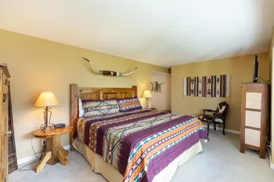 a bedroom with a bed and a table and a chair at 2534 Saints Johns condo in Keystone