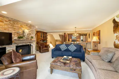 a living room with a blue couch and a fireplace at 2534 Saints Johns condo in Keystone