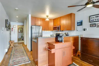 a kitchen with wooden cabinets and a stainless steel refrigerator at 8 Mi to Keystone Resort Dillion Condo with Hot Tub! in Dillon