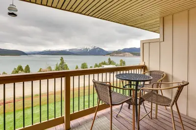 a balcony with a table and chairs and a view of the water at 8 Mi to Keystone Resort Dillion Condo with Hot Tub! in Dillon