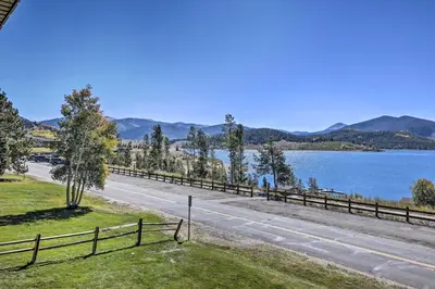 a road next to a lake with mountains in the background at 8 Mi to Keystone Resort Dillion Condo with Hot Tub! in Dillon