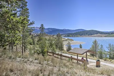 a person sitting under a pavilion next to a lake at 8 Mi to Keystone Resort Dillion Condo with Hot Tub! in Dillon