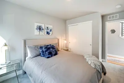 a bedroom with a bed with a blue pillow on it at Heated Rooftop Deck and Mtn Views Denver Retreat in Englewood
