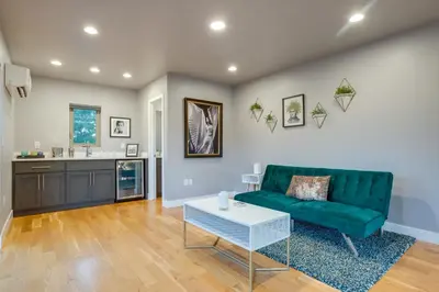 a living room with a green couch and a table at Heated Rooftop Deck and Mtn Views Denver Retreat in Englewood