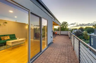 a balcony of a house with a green couch at Heated Rooftop Deck and Mtn Views Denver Retreat in Englewood