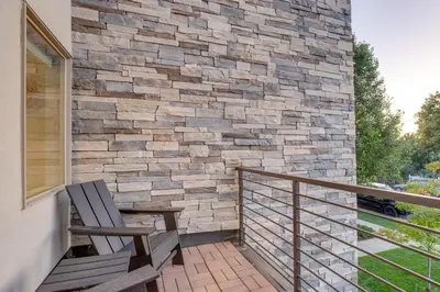 a balcony with a bench and a stone wall at Heated Rooftop Deck and Mtn Views Denver Retreat in Englewood