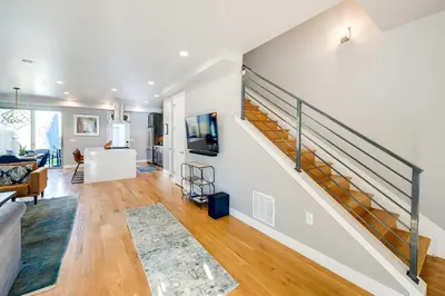 a living room with a staircase in a house at Heated Rooftop Deck and Mtn Views Denver Retreat in Englewood