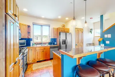a kitchen with wooden cabinets and a island with bar stools at WinterStar E-2 in Fraser