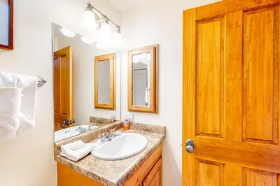 a bathroom with a sink and a wooden door at WinterStar E-2 in Fraser
