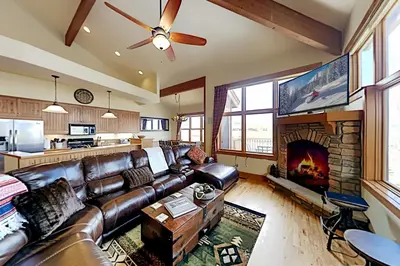 a living room with a leather couch and a fireplace at Mountain Sky in Granby
