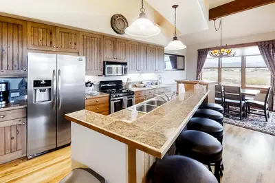 a kitchen with stainless steel appliances and wooden cabinets at Mountain Sky in Granby