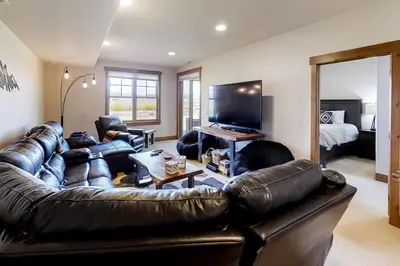 a living room with a leather couch and a television at Mountain Sky in Granby