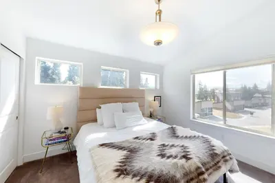 a bedroom with a bed and a large window at Mountain Sky Cottage in Fraser