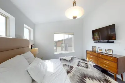 a bedroom with a bed and a tv and a dresser at Mountain Sky Cottage in Fraser