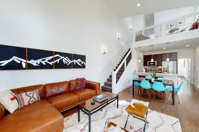 a living room with a couch and a dining room at Mountain Sky Cottage in Fraser