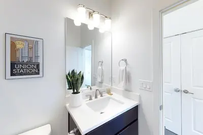 a white bathroom with a sink and a mirror at Mountain Sky Cottage in Fraser