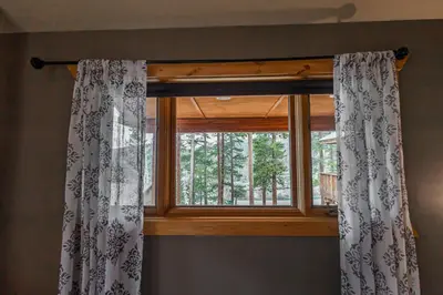 a window with a curtain in a room at Mountain Calling in Grand Lake