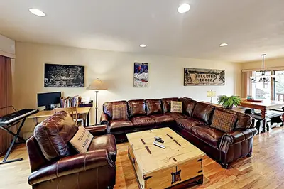 a living room with leather couches and a table at Saw Mill Station 127 in Winter Park