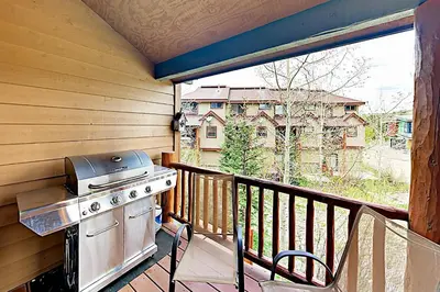 a porch with a grill and a stove on a balcony at Saw Mill Station 127 in Winter Park