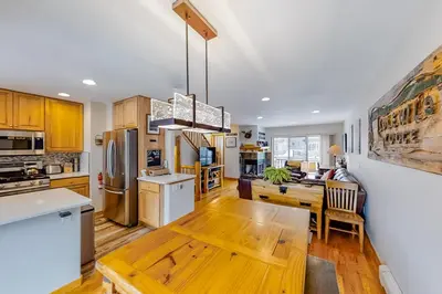 a kitchen with a wooden table and a dining room at Saw Mill Station 127 in Winter Park