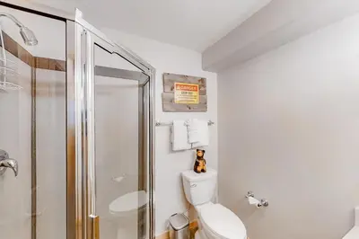a white bathroom with a toilet and a shower at Saw Mill Station 127 in Winter Park
