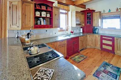 a kitchen with wooden cabinets and a stove top oven at Hilltop Palace in Fraser