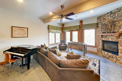 a living room with a couch and a piano at Hilltop Palace in Fraser