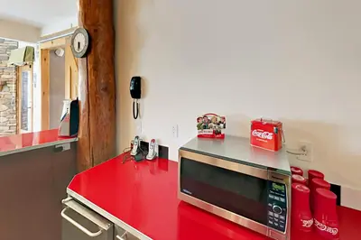 a kitchen with a red counter top with a microwave at Hilltop Palace in Fraser