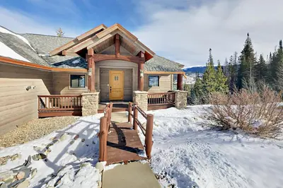 a house in the snow with a wooden door at Hilltop Palace in Fraser
