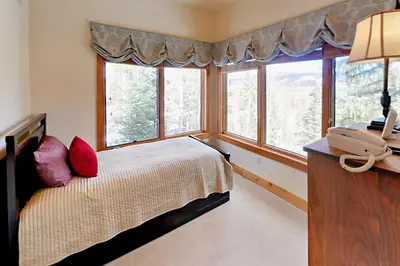 a bedroom with a bed and a phone on a desk at Hilltop Palace in Fraser
