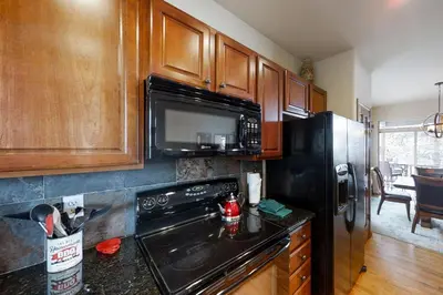 a kitchen with a black appliances and wooden cabinets at Deer Track Retreat in Granby