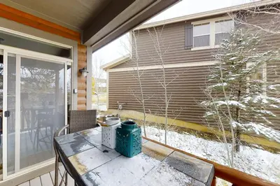 a screened porch with a table and a window at Deer Track Retreat in Granby