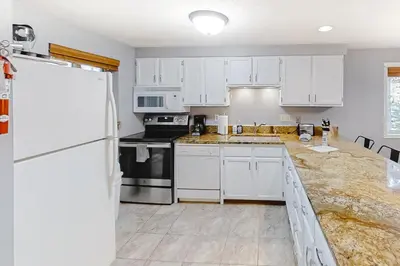 a kitchen with white cabinets and a white refrigerator at Beaver Village 15-11 in Winter Park