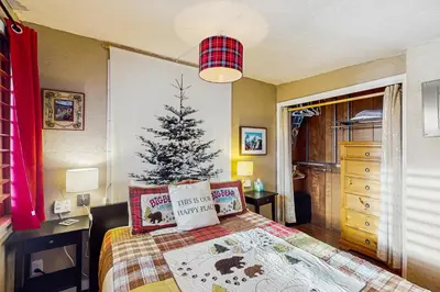 a bedroom with a christmas tree on a bed at Winter Park Meadows Lodge in Fraser