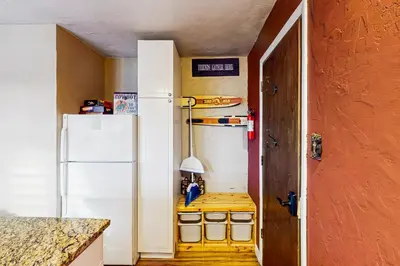 a kitchen with a white refrigerator and a table at Winter Park Meadows Lodge in Fraser