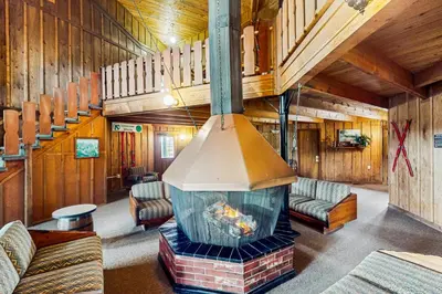 a living room with a fireplace in a log cabin at Winter Park Meadows Lodge in Fraser