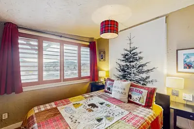a bedroom with a christmas tree next to a bed at Winter Park Meadows Lodge in Fraser