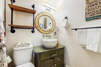 a bathroom with a sink and a toilet and a mirror at Winter Park Meadows Lodge in Fraser