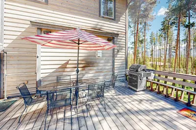 a patio with a table and an umbrella and a grill at Big Bear Palace in Fraser