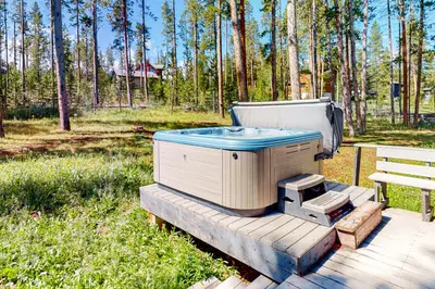 a hot tub sitting on a deck next to a bench at Big Bear Palace in Fraser