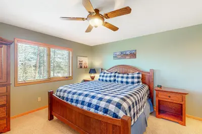 a bedroom with a bed and a ceiling fan at Big Bear Palace in Fraser