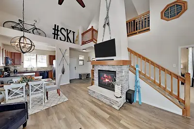 a living room with a fireplace and a tv at Summit Point Place in Granby