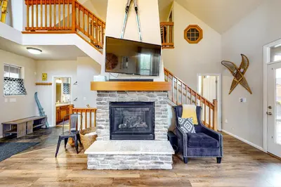a living room with a fireplace and a staircase at Summit Point Place in Granby